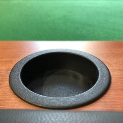 Black plastic cup holder installed in table